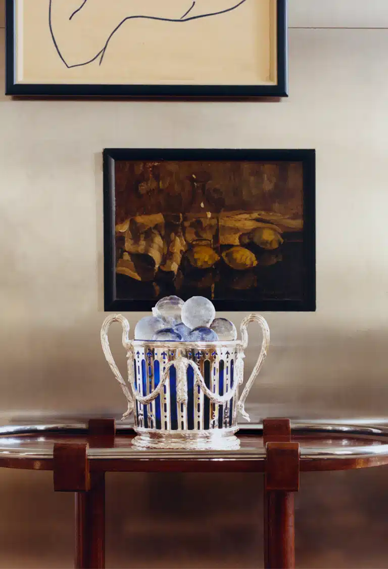 Seau à champagne avec insert en verre bleu de Murano, posé sur une table roulante devant un cadre