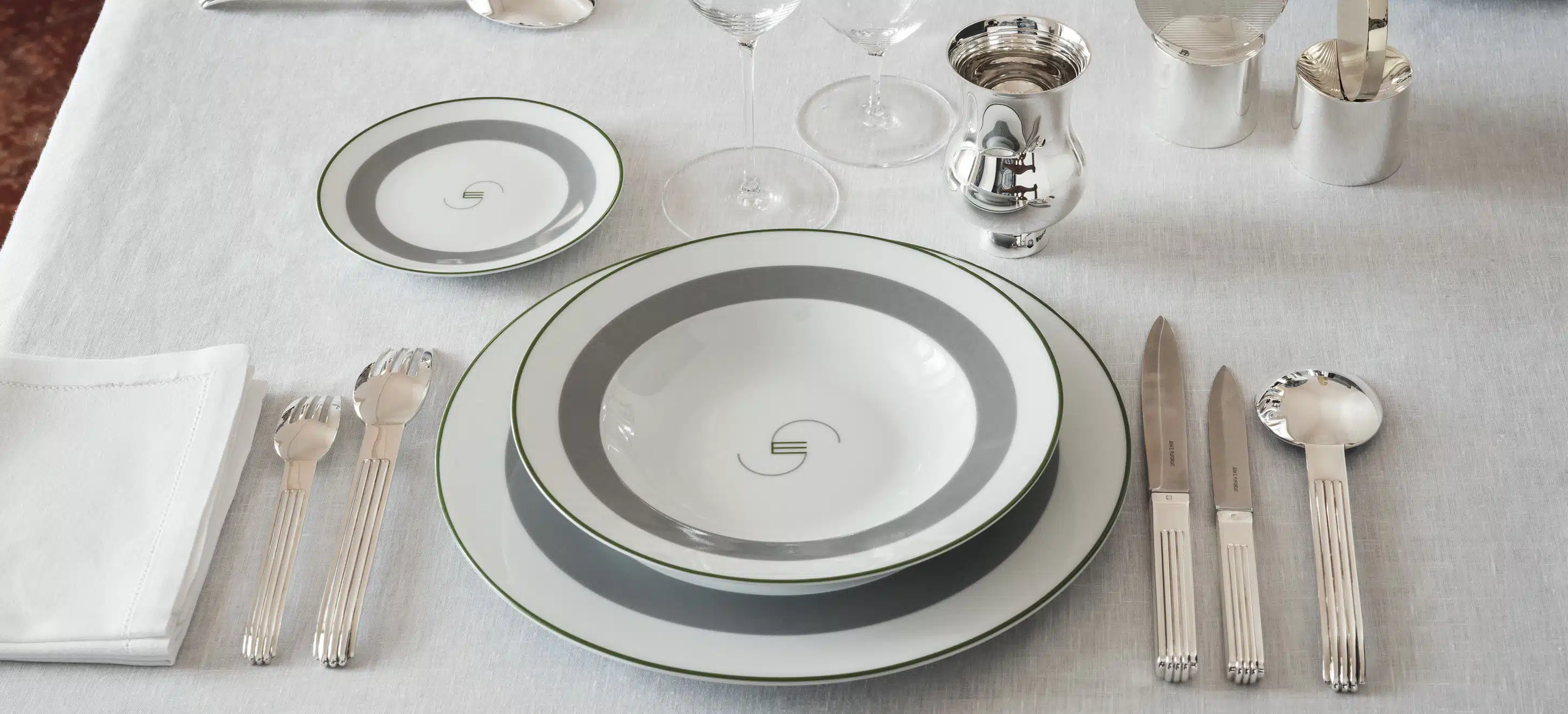 Table dressée de pièces en argent massif et assiettes à pain, creuse et à dîner de la collection Monogrammes de Puiforcat