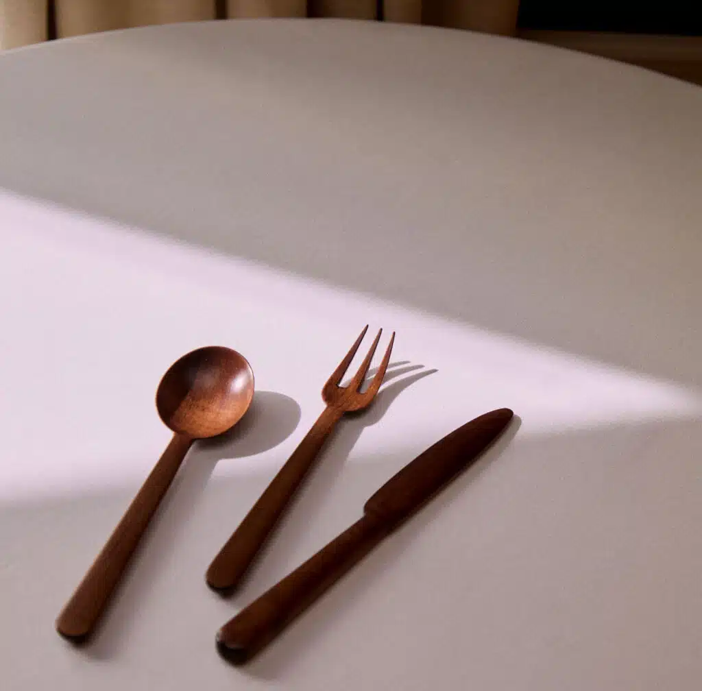 Couverts Jersey en bois de cerisier sur une table blanche