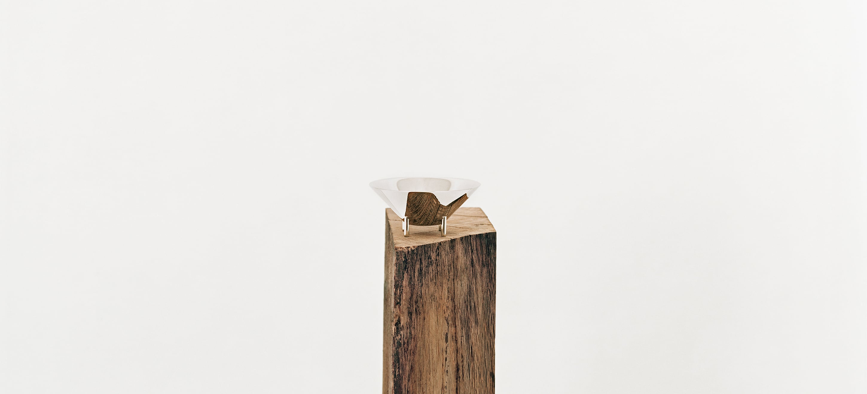 Verre 01 de la collection Kanmi, réalisée en collaboration avec Tomás Alonso, posé sur une poutre en bois