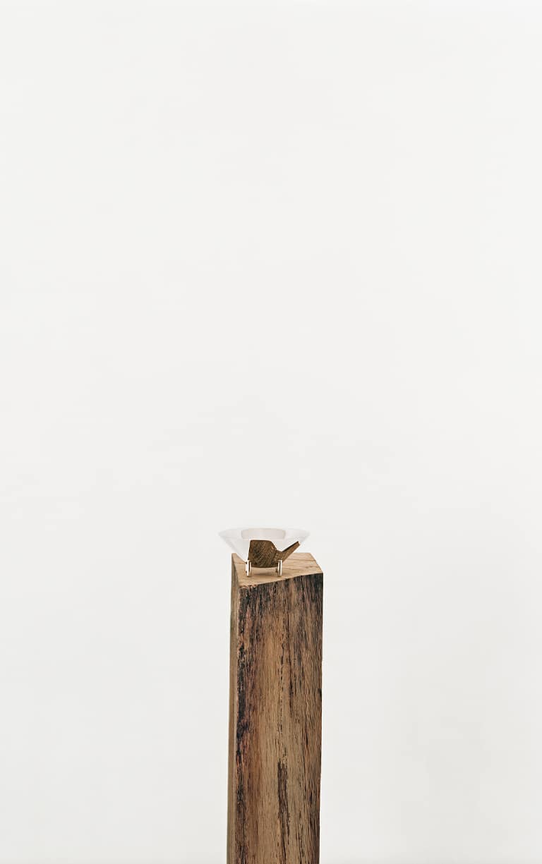 Verre 01 de la collection Kanmi, réalisée en collaboration avec Tomás Alonso, posé sur une poutre en bois